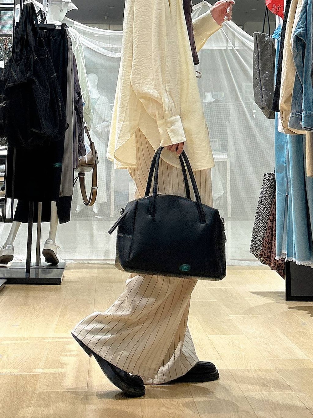 ブラック系のボストンバッグ、ホワイト系のその他パンツ、イエロー系のシャツ/ブラウスを着用したレディースの春コーディネートの4枚目の写真