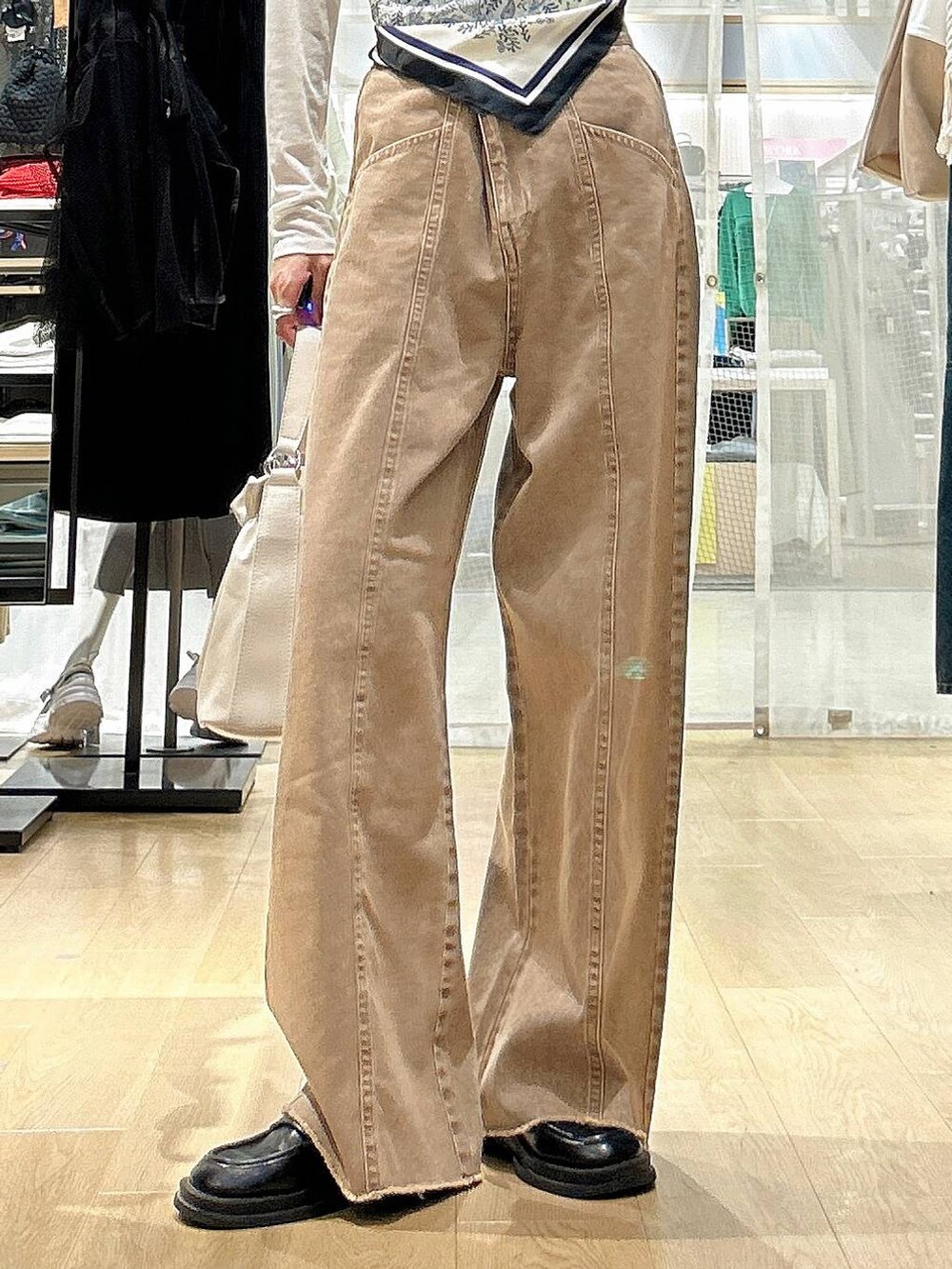 ホワイト系のTシャツ/カットソー、ホワイト系のショルダーバッグ、ベージュ系のデニムパンツを着用したレディースの春コーディネートの3枚目の写真