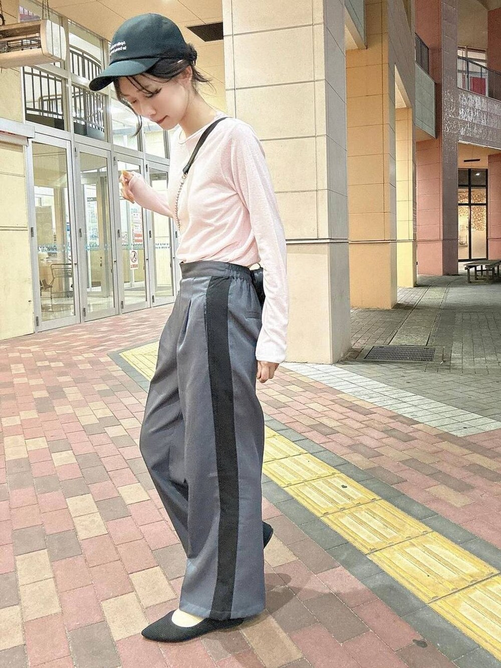 ブラック系のショルダーバッグ、グレー系のその他パンツ、ピンク系のTシャツ/カットソーを着用したレディースの春コーディネートの4枚目の写真