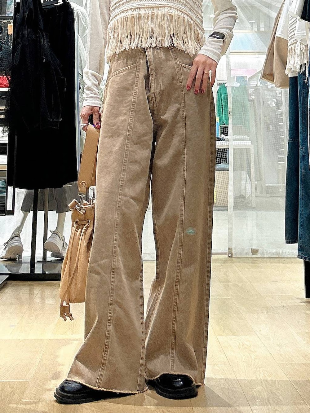 ホワイト系のTシャツ/カットソー、ブラウン系のショルダーバッグ、ベージュ系のベストを着用したレディースの春コーディネートの3枚目の写真