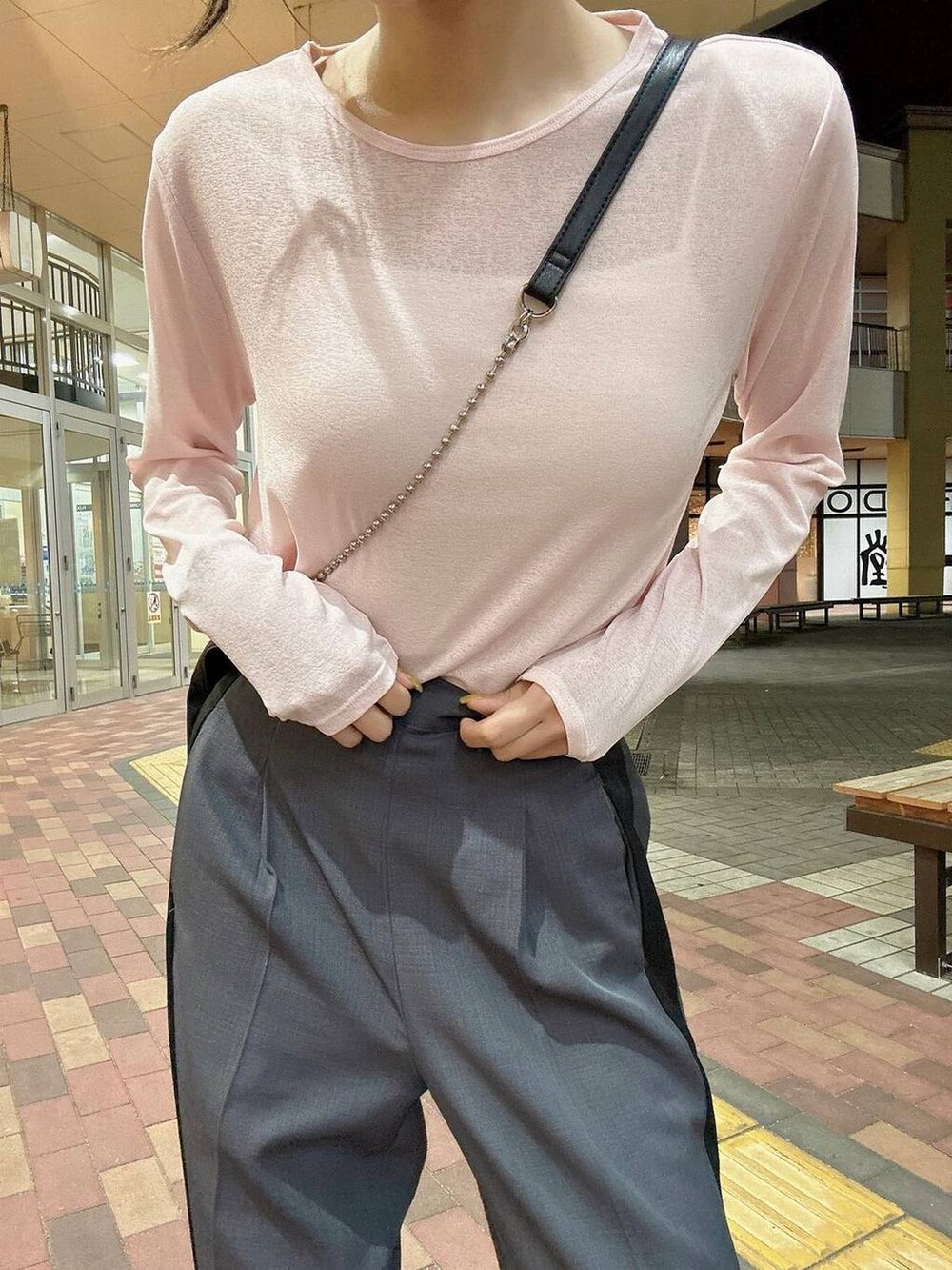 ブラック系のショルダーバッグ、グレー系のその他パンツ、ピンク系のTシャツ/カットソーを着用したレディースの春コーディネートの3枚目の写真