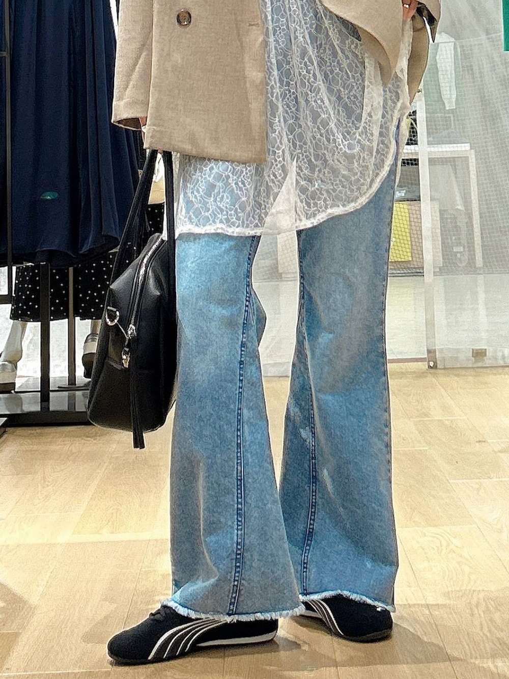 ブラック系のボストンバッグ、ブルー系のデニムパンツ、ブラウン系のテーラードジャケットを着用したレディースの春コーディネートの3枚目の写真