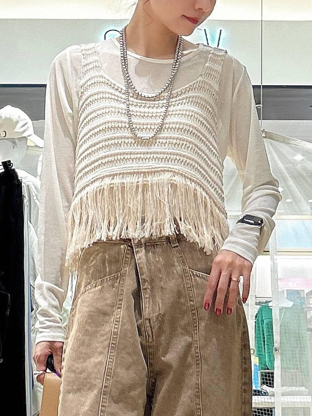 ホワイト系のTシャツ/カットソー、ブラウン系のショルダーバッグ、ベージュ系のベストを着用したレディースの春コーディネートの2枚目の写真