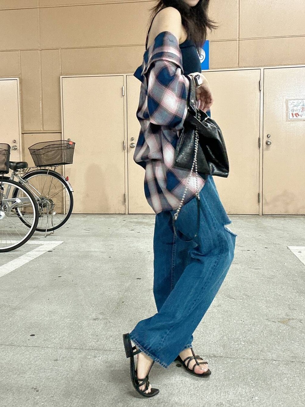 ブラック系のショルダーバッグ、ブルー系のキャミソール、ブルー系のデニムパンツを着用したレディースの夏コーディネートの5枚目の写真