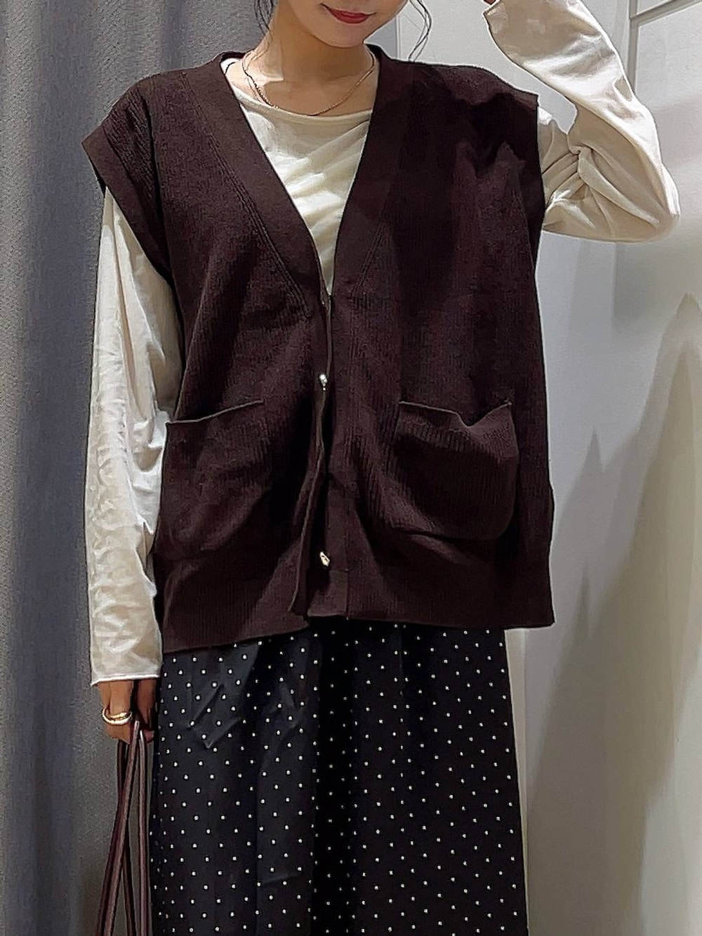 レッド系のボストンバッグ、ベージュ系のTシャツ/カットソー、その他のスカートを着用したレディースの秋コーディネートの3枚目の写真