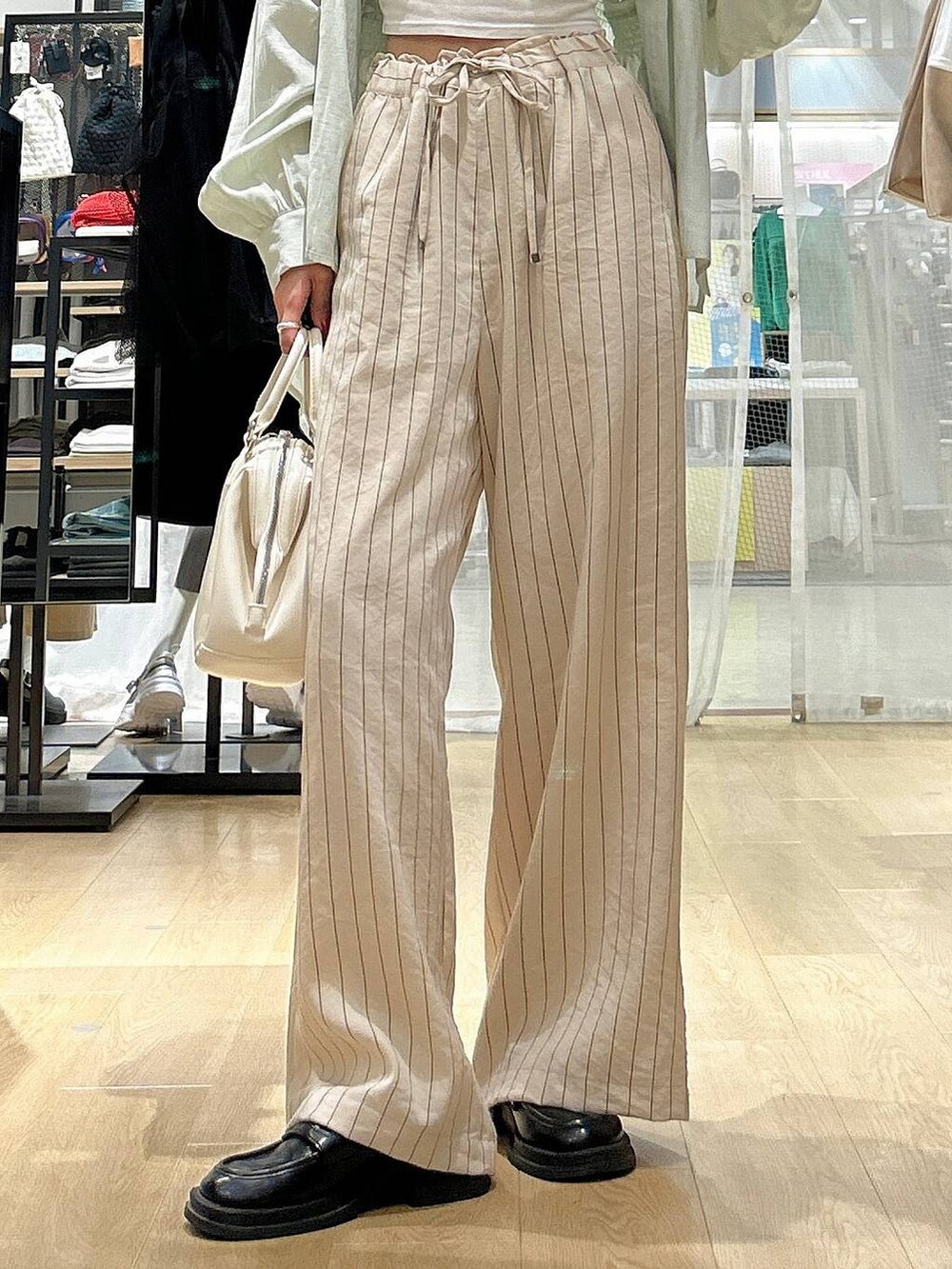 ホワイト系のショルダーバッグ、ホワイト系のその他パンツ、グリーン系のその他トップスを着用したレディースの春コーディネートの3枚目の写真