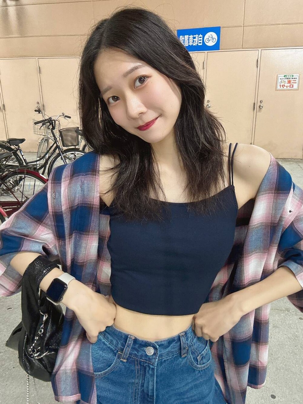 ブラック系のショルダーバッグ、ブルー系のキャミソール、ブルー系のデニムパンツを着用したレディースの夏コーディネートの6枚目の写真