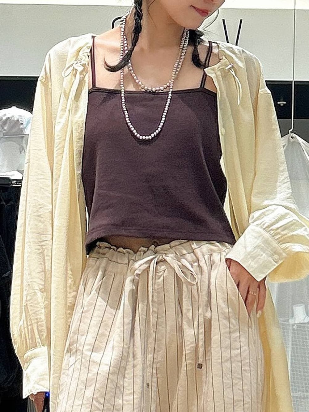 ブラック系のボストンバッグ、ホワイト系のその他パンツ、イエロー系のシャツ/ブラウスを着用したレディースの春コーディネートの3枚目の写真