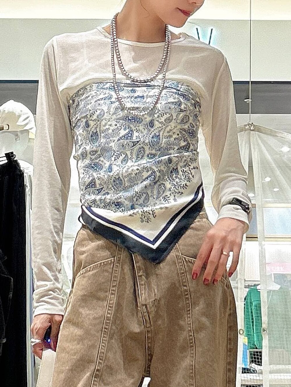 ホワイト系のTシャツ/カットソー、ホワイト系のショルダーバッグ、ベージュ系のデニムパンツを着用したレディースの春コーディネートの2枚目の写真