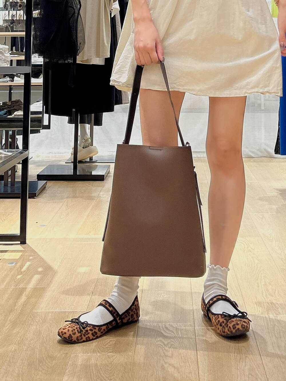 ブラウン系のショルダーバッグ、ベージュ系のチュニック、ホワイト系のソックス/靴下を着用したレディースの夏コーディネートの3枚目の写真