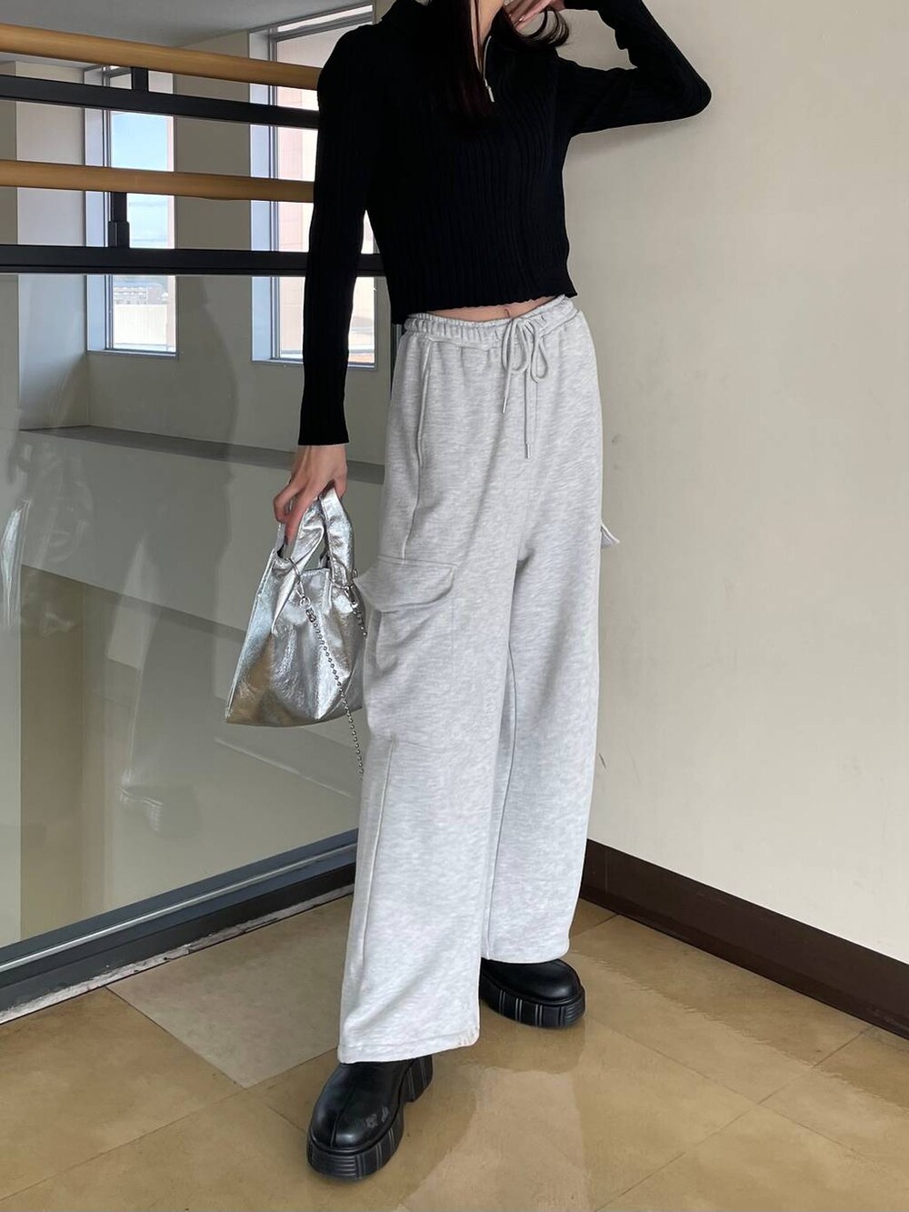 ブラック系のカーディガン/ボレロ、シルバー系のショルダーバッグ、グレー系のスウェットパンツを着用したレディースの春コーディネートの3枚目の写真