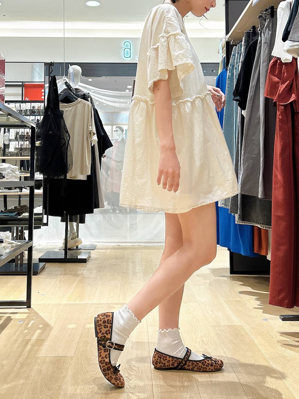 ブラウン系のショルダーバッグ、ベージュ系のチュニック、ホワイト系のソックス/靴下を着用したレディースの夏コーディネートの4枚目の写真