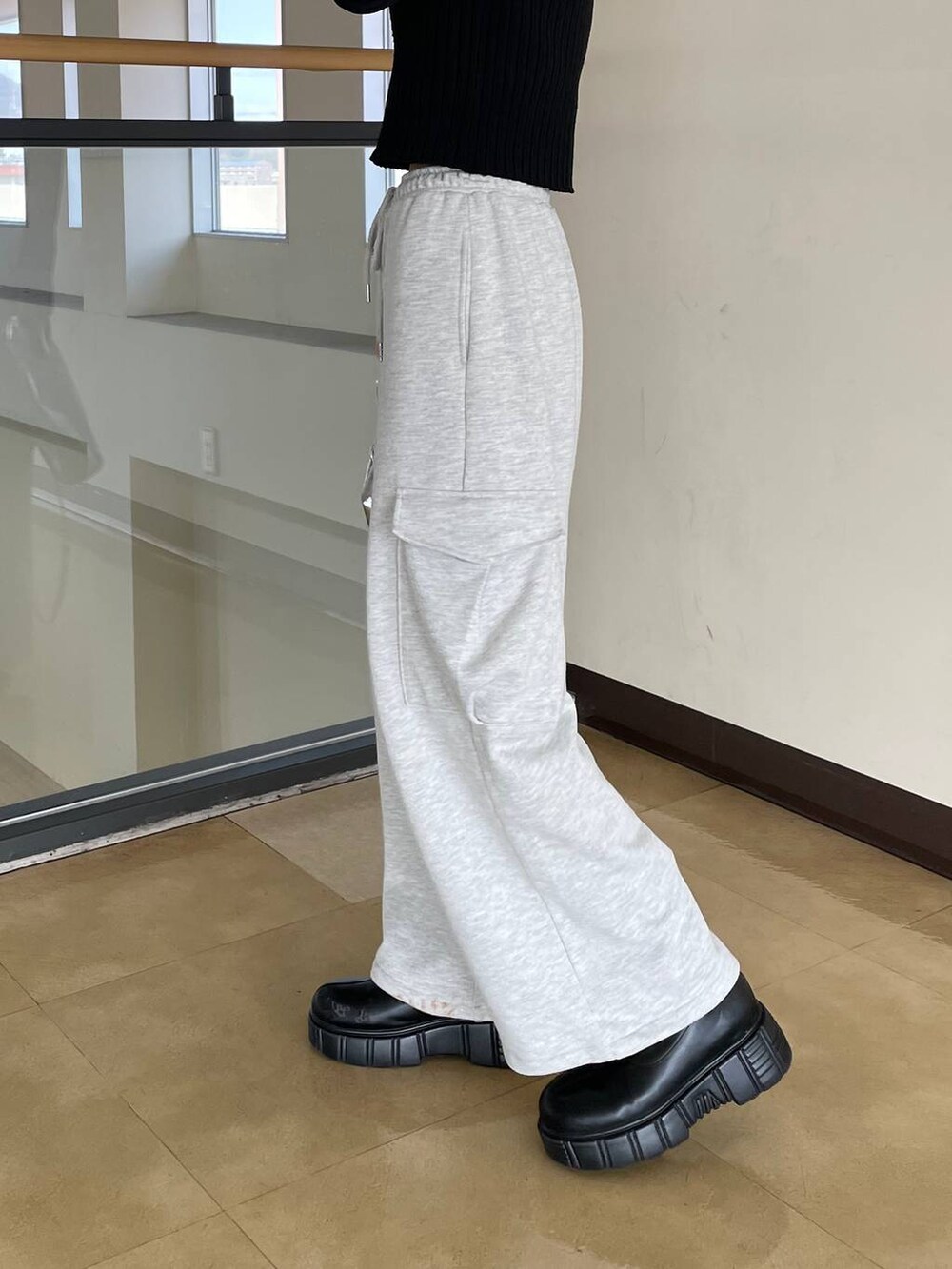 ブラック系のカーディガン/ボレロ、シルバー系のショルダーバッグ、グレー系のスウェットパンツを着用したレディースの春コーディネートの2枚目の写真