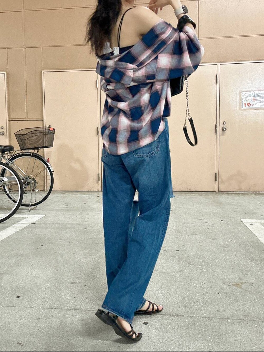 ブラック系のショルダーバッグ、ブルー系のキャミソール、ブルー系のデニムパンツを着用したレディースの夏コーディネートの2枚目の写真