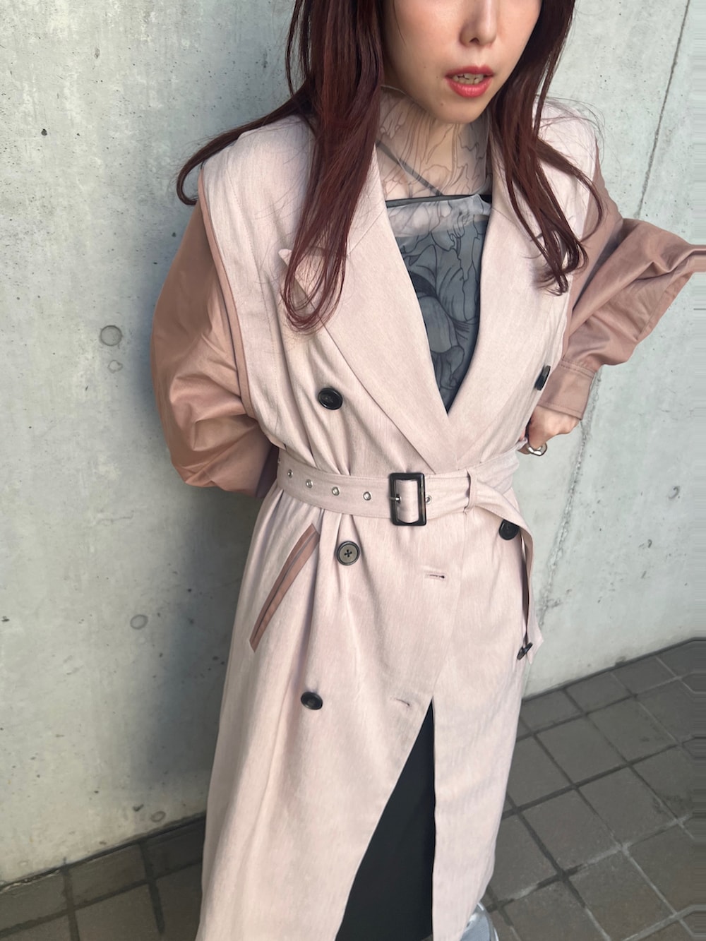 グレー系のスニーカー、ブラック系のワンピース、ピンク系のトレンチコートを着用したレディースの春コーディネートの3枚目の写真