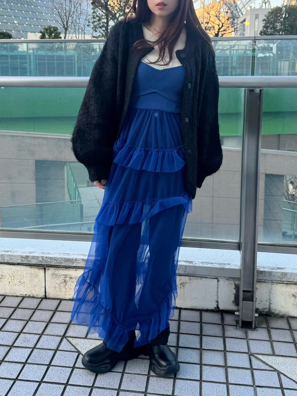 ブルー系のワンピース/ドレス、ブラック系のカーディガン/ボレロ、ブラック系のブーツを着用したレディースの冬コーディネートの2枚目の写真