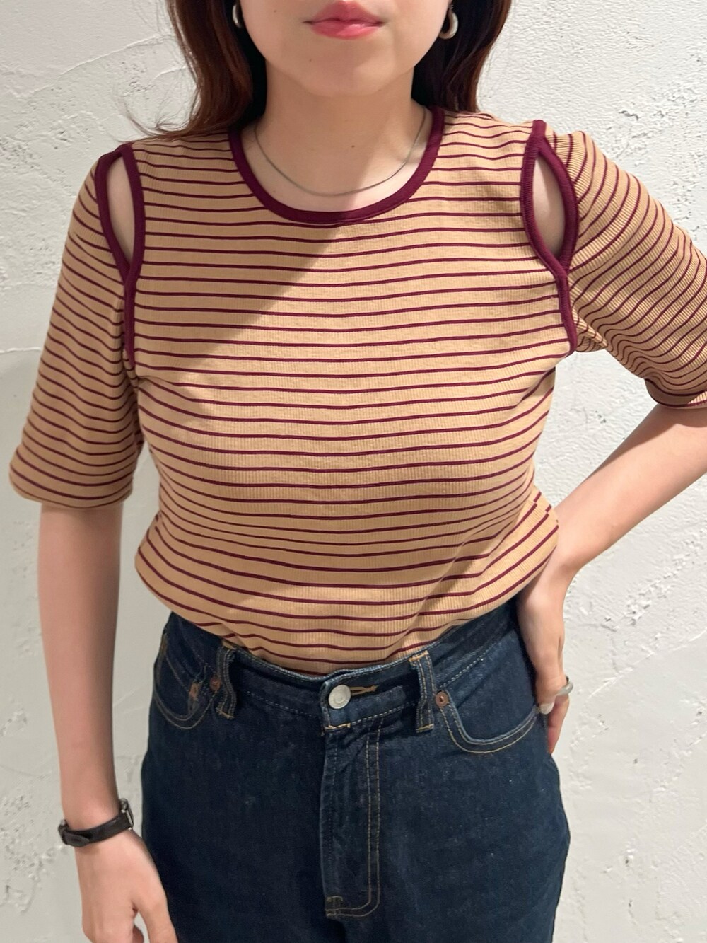 ベージュ系のTシャツ/カットソー、ブラック系のデニムパンツ、ブラック系のサンダルを着用したレディースの夏コーディネートの2枚目の写真