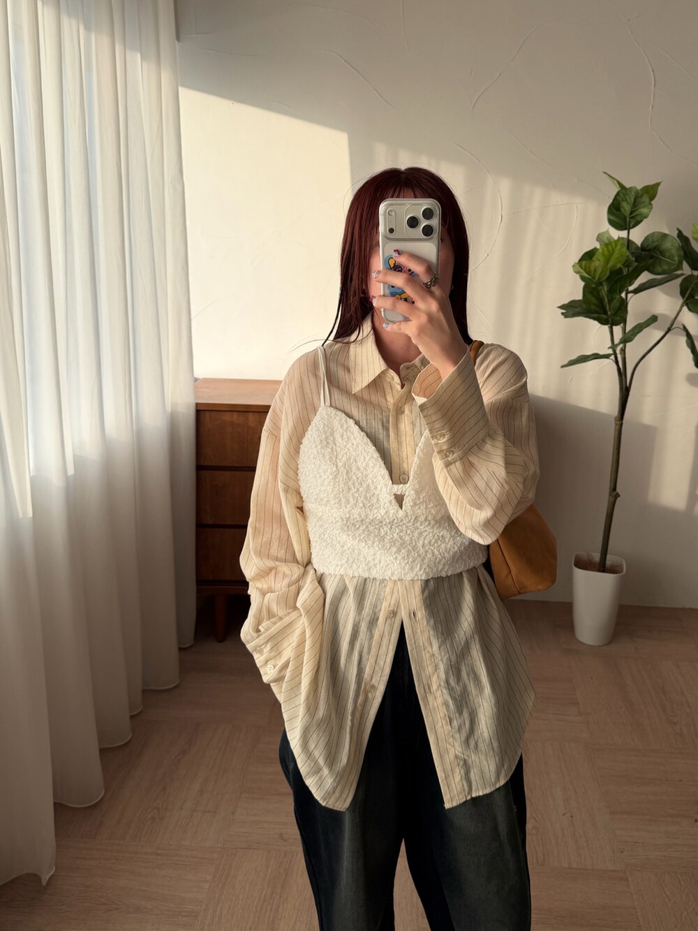 ブラック系のデニムパンツを着用したレディースの春コーディネートの2枚目の写真