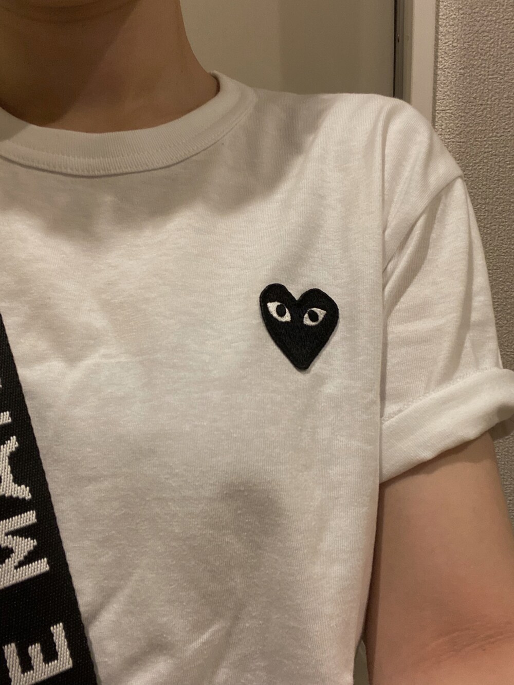 ブラック系のスラックス、ブラック系のショルダーバッグ、ホワイト系のTシャツ/カットソーを着用したレディースの夏コーディネートの2枚目の写真