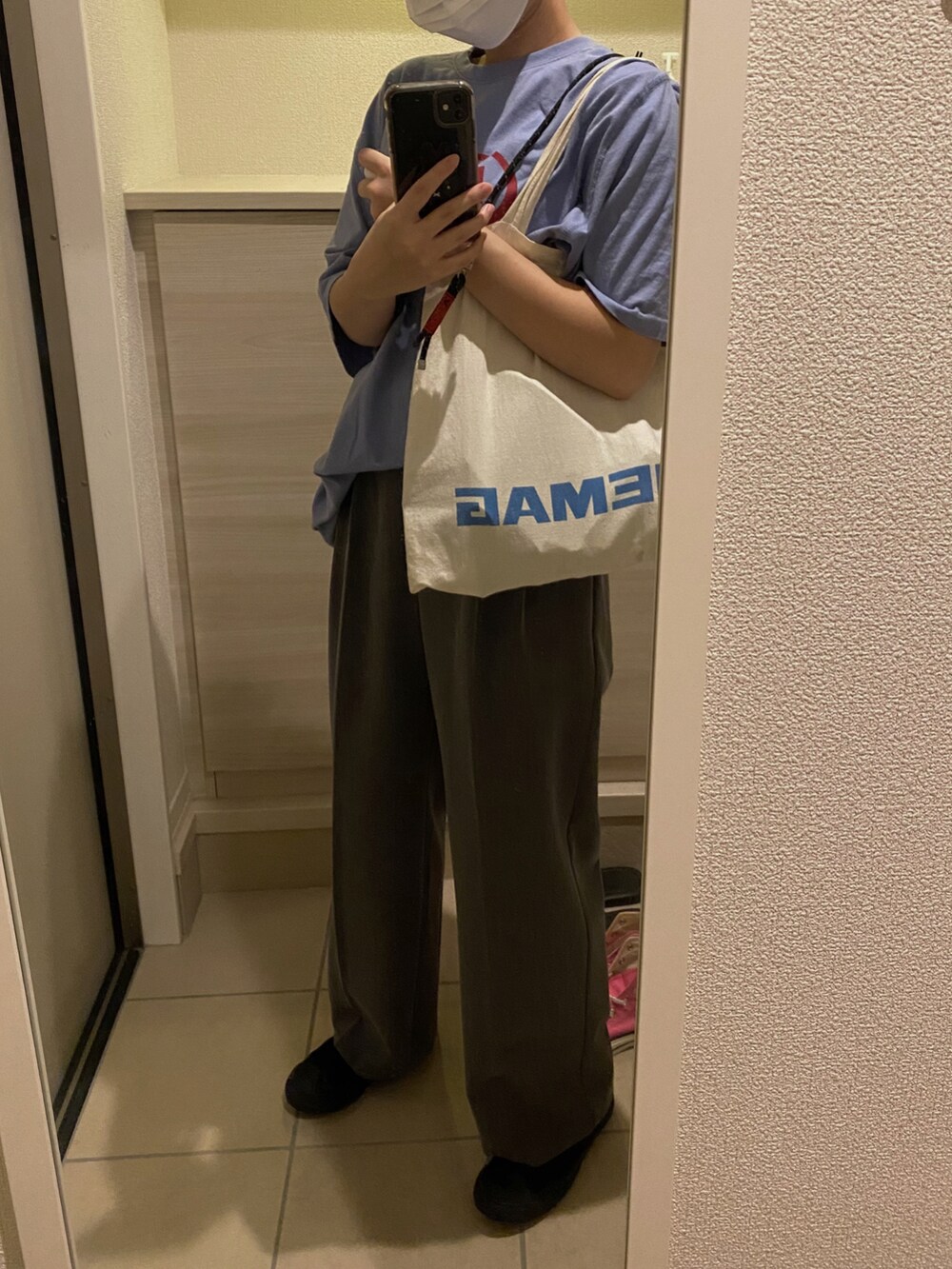 グレー系のスラックス、ブラック系のスニーカー、ブルー系のTシャツ/カットソーを着用したレディースの秋コーディネートの2枚目の写真