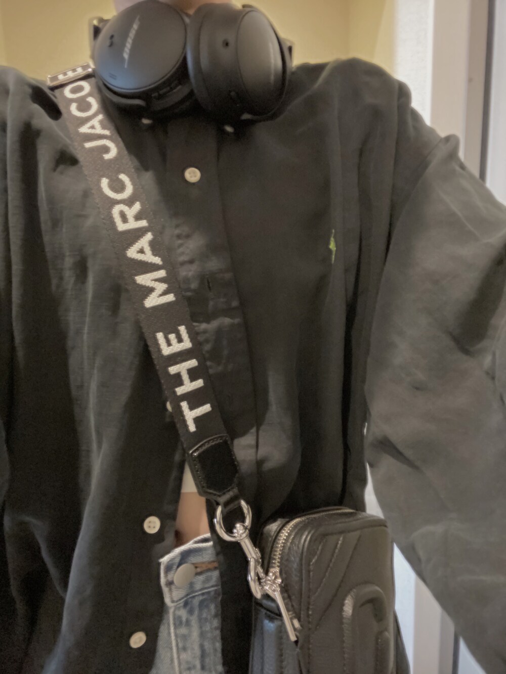 ブルー系のシャツ/ブラウス、ブルー系のデニムパンツ、ブラック系のショルダーバッグを着用したレディースの春コーディネートの2枚目の写真