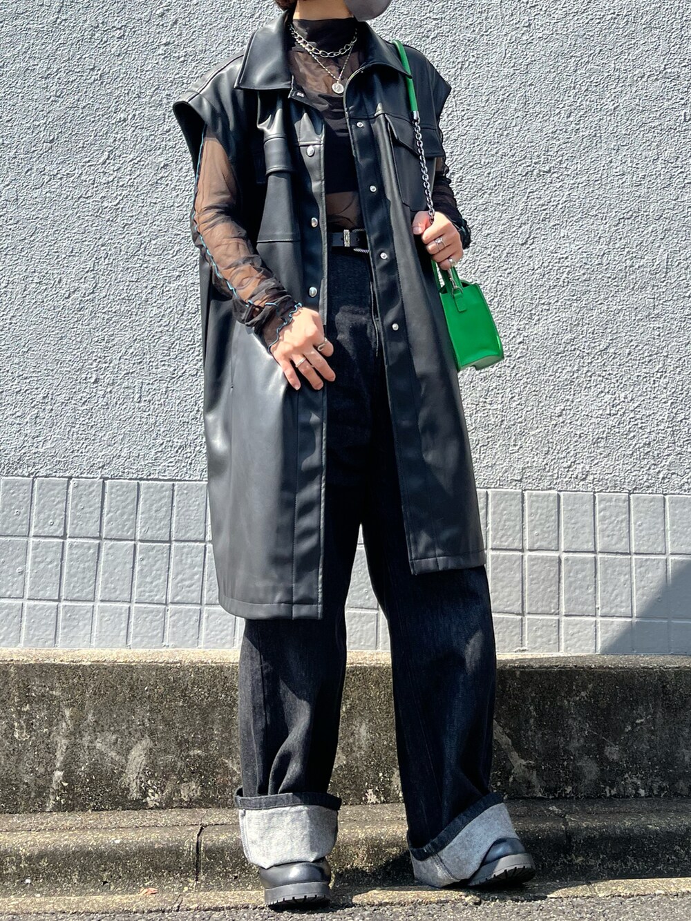 ブラック系のTシャツ/カットソー、ブラック系のブルゾン、グリーン系のバッグを着用したレディースの秋コーディネートの2枚目の写真