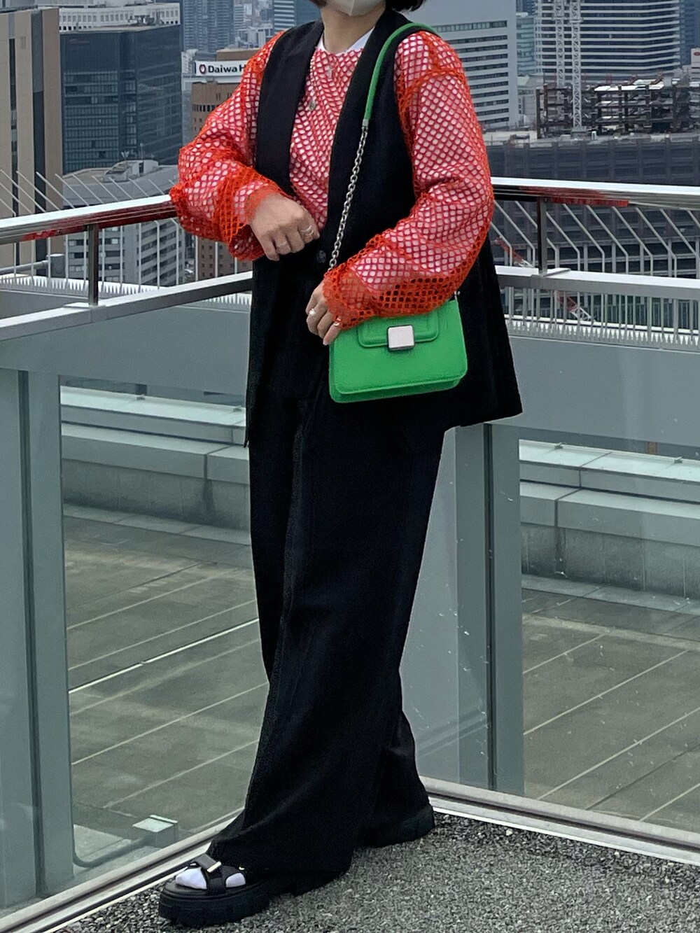 オレンジ系のTシャツ/カットソー、ホワイト系のTシャツ/カットソー、ブラック系のその他アウターを着用したレディースの秋コーディネートの2枚目の写真