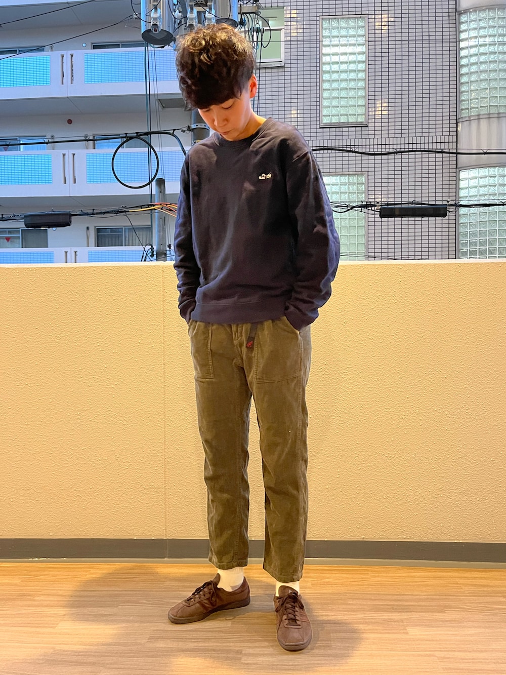 ブラック系のその他アウター、グリーン系のその他パンツ、ブラウン系のスニーカーを着用したメンズの秋コーディネートの2枚目の写真