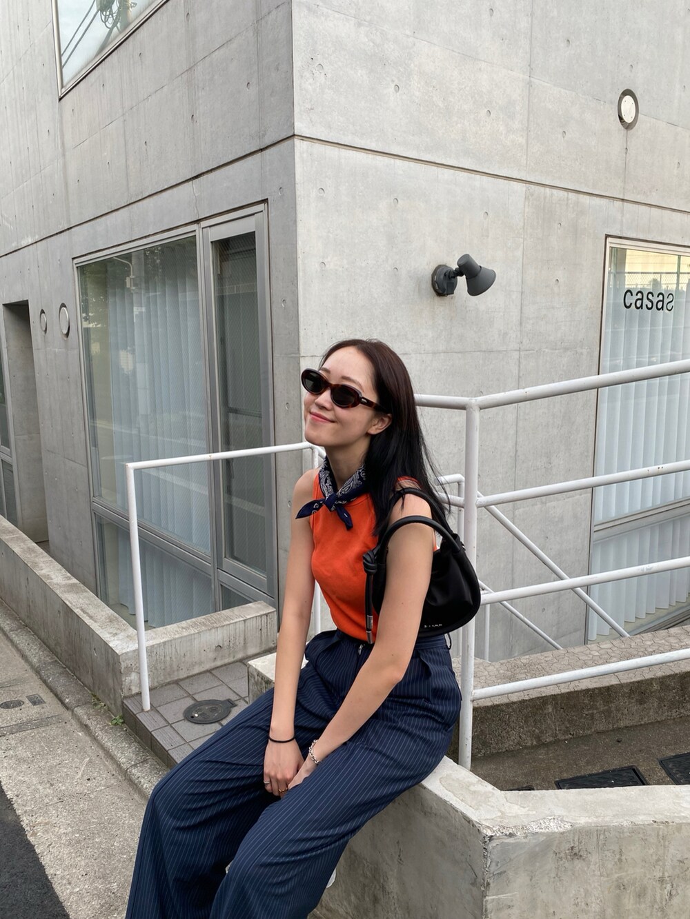 ブラック系のショルダーバッグ、その他のスニーカー、ブラウン系のメガネを着用したレディースの春コーディネートの2枚目の写真