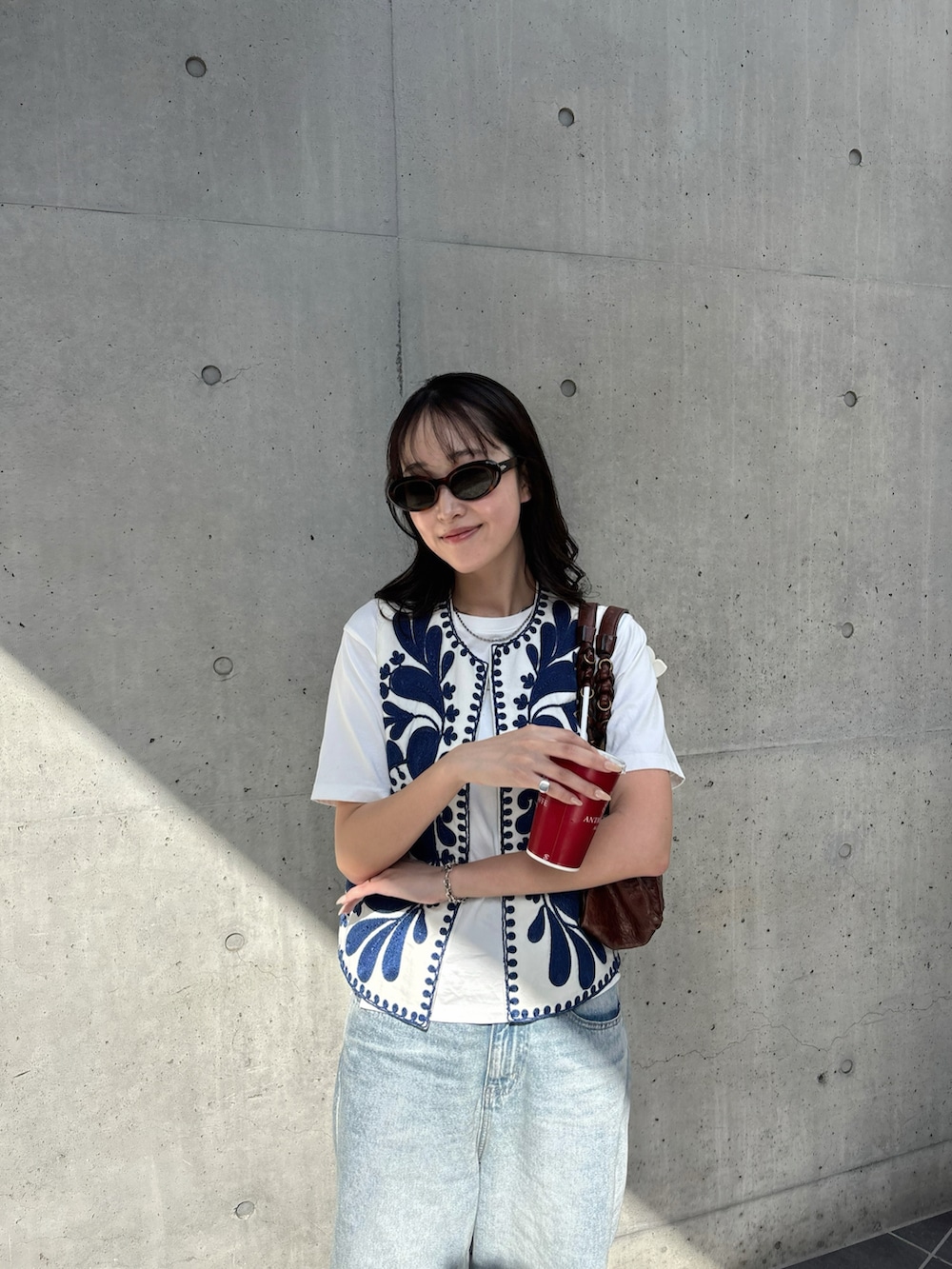 ブルー系のデニムパンツ、ベージュ系のブーツを着用したレディースの春コーディネートの2枚目の写真