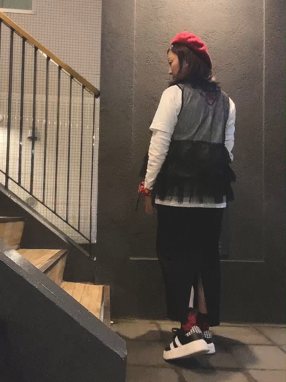 ブラック系のジャンパースカート、ホワイト系のTシャツ/カットソー、ブラック系のベストを着用したレディースの秋コーディネートの2枚目の写真