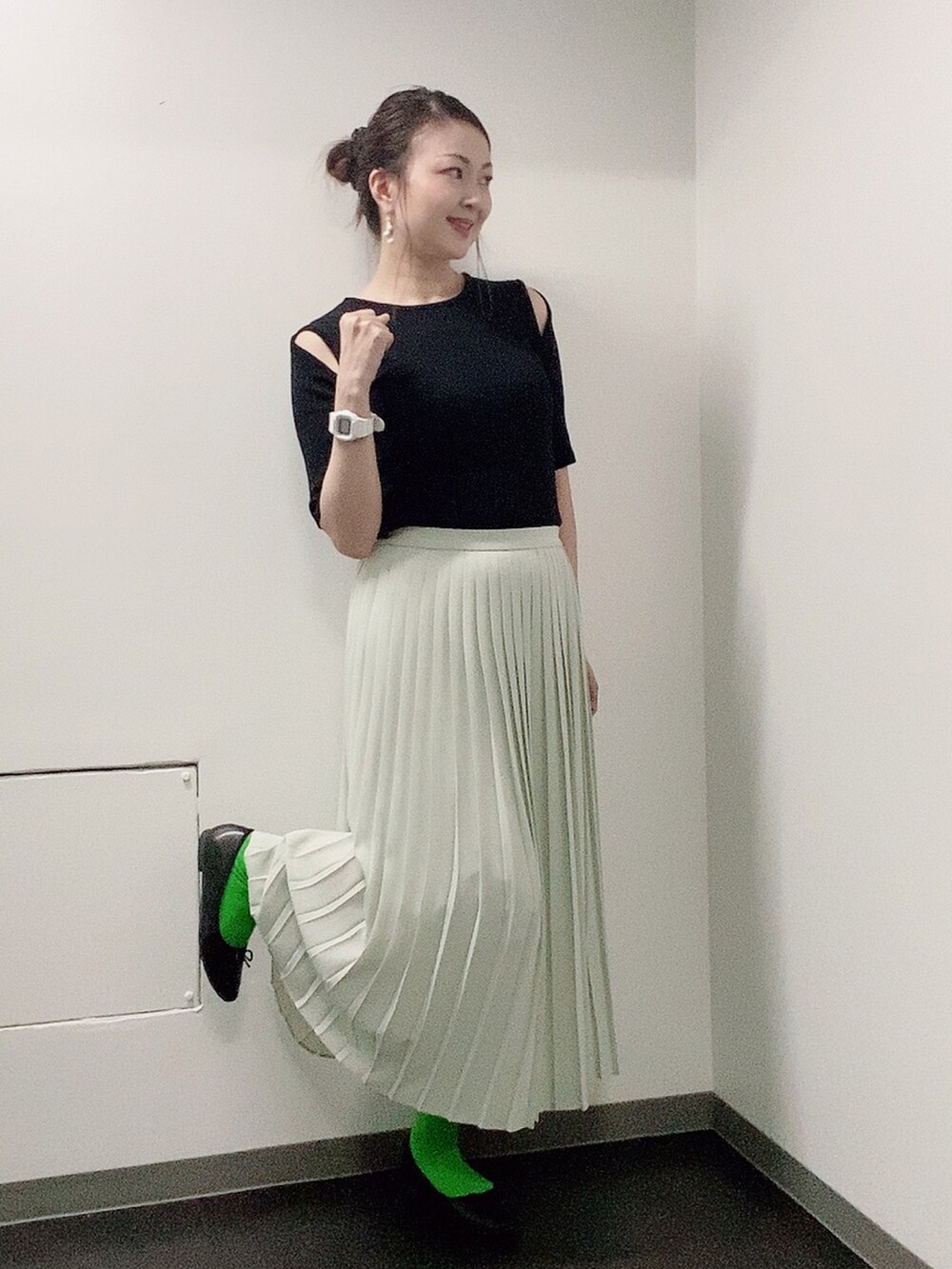 ブラック系のニット/セーター、グリーン系のスカート、ブラック系のレインシューズを着用したレディースの夏コーディネートの2枚目の写真