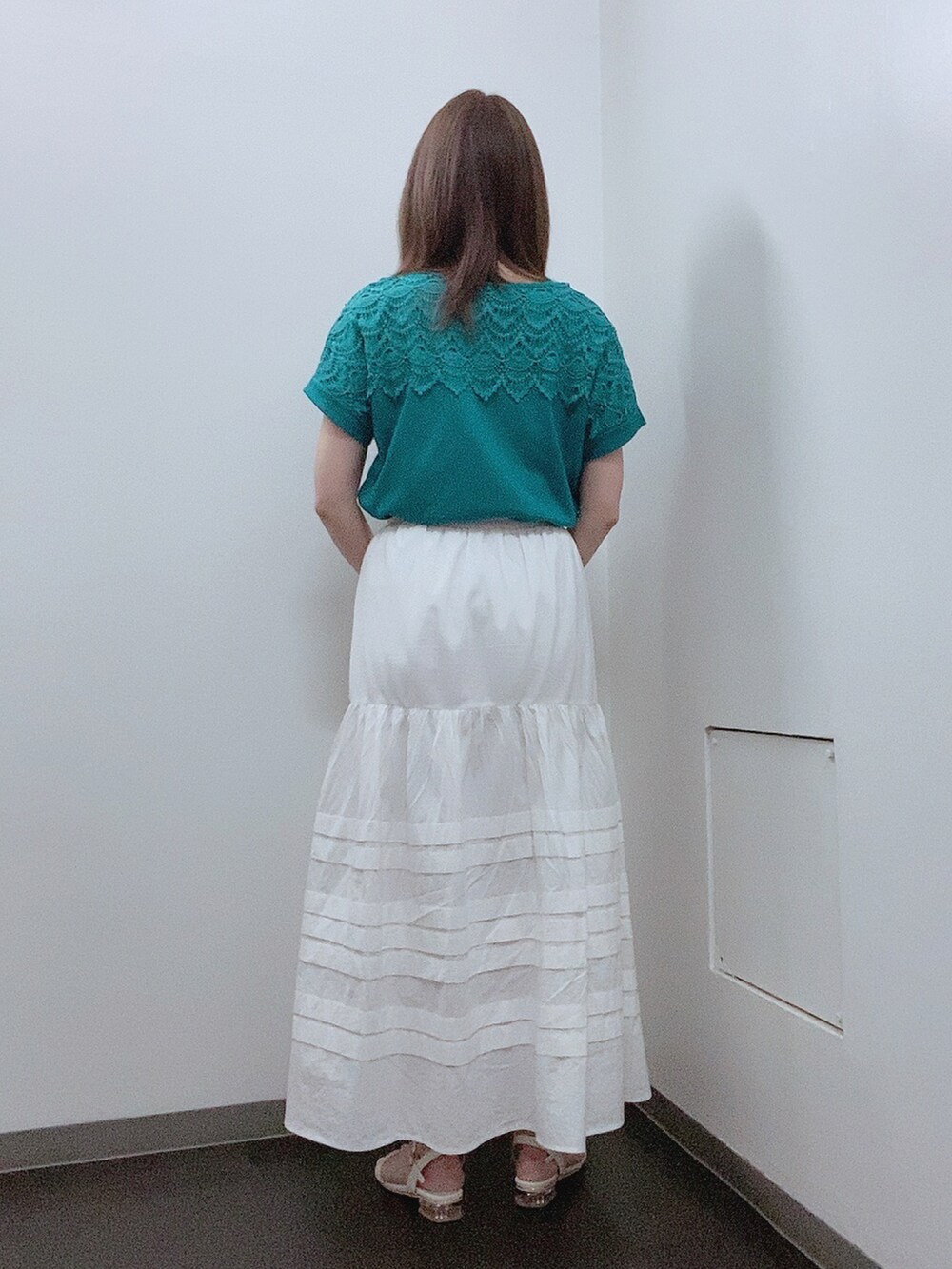 ホワイト系のスカート、ホワイト系のサンダル、グリーン系のTシャツ/カットソーを着用したレディースの夏コーディネートの3枚目の写真