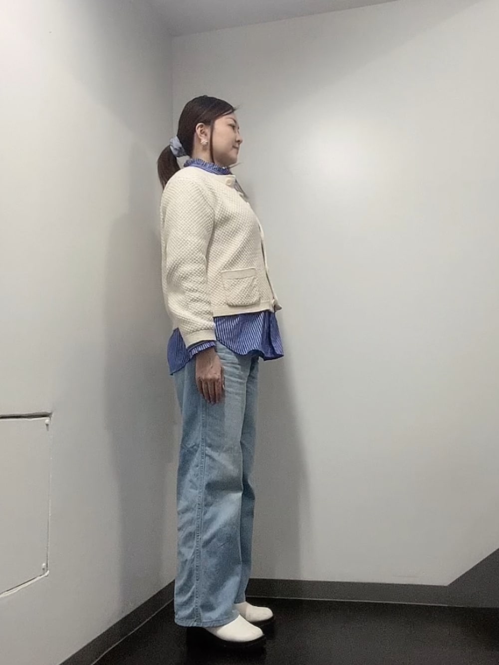 ホワイト系のカーディガン/ボレロ、ブルー系のシャツ/ブラウス、ブルー系のデニムパンツを着用したレディースの冬コーディネートの2枚目の写真