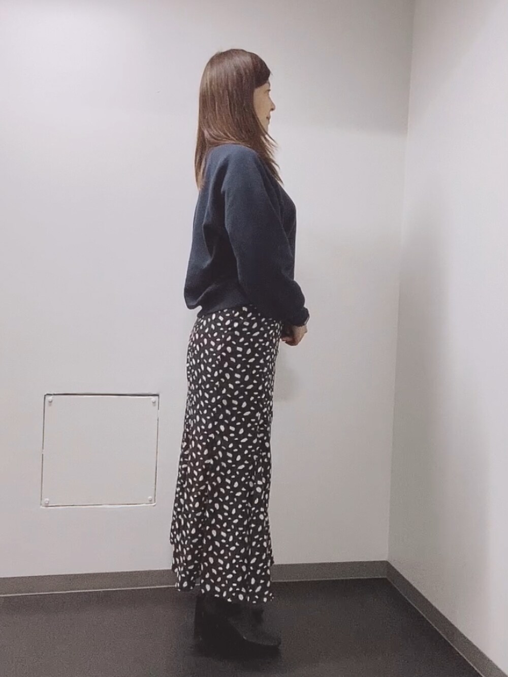 ブルー系のスウェット、ブラック系のスカート、ブラック系のブーツを着用したレディースの秋コーディネートの2枚目の写真