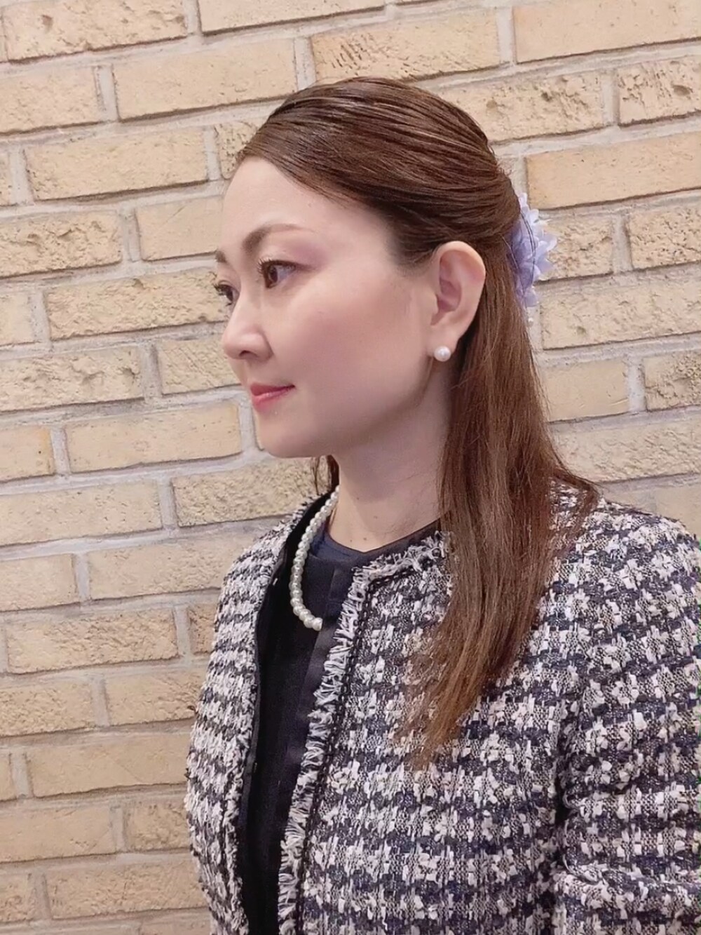 ブルー系のスーツセット、ブラック系のパンプス、ブルー系のTシャツ/カットソーを着用したレディースの春コーディネートの2枚目の写真