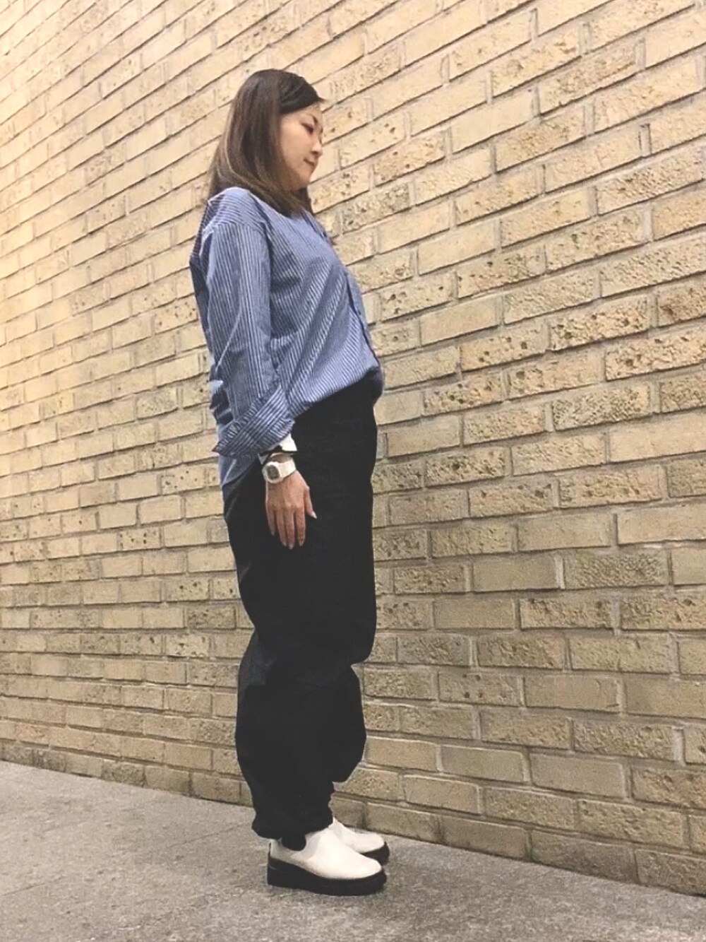 ブルー系のシャツ/ブラウス、ブラック系のカーゴパンツ、ホワイト系のレインシューズを着用したレディースの春コーディネートの3枚目の写真