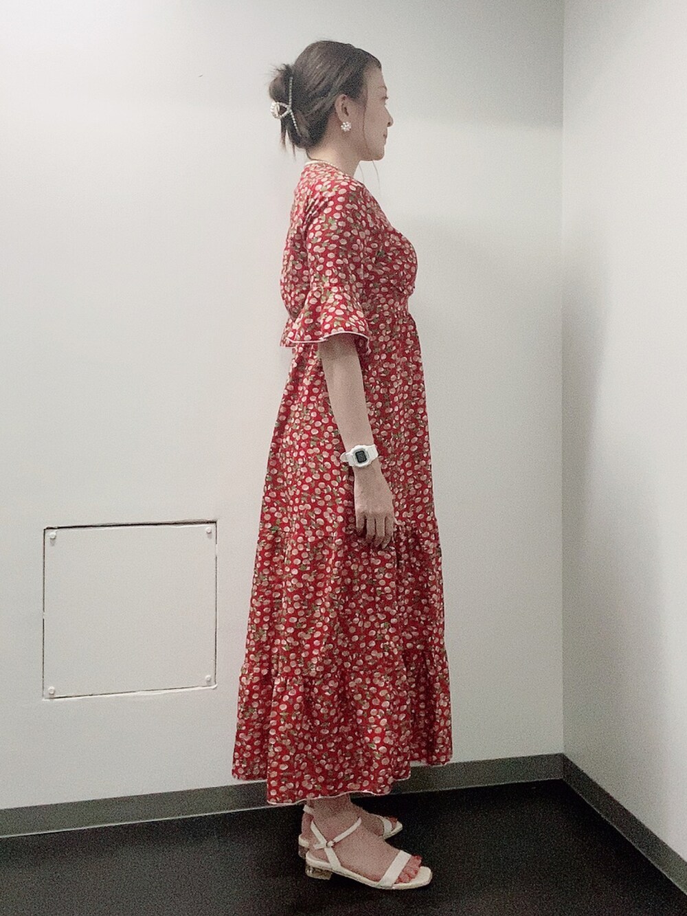 レッド系のワンピース、ホワイト系のサンダル、ホワイト系のタンクトップを着用したレディースの夏コーディネートの2枚目の写真