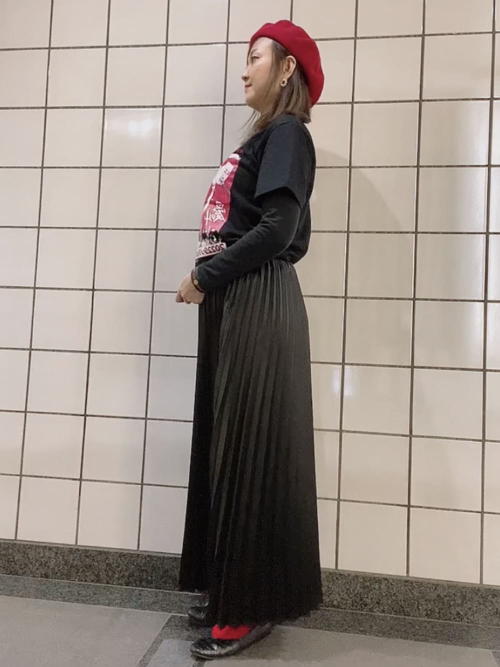 ブラック系のTシャツ/カットソー、ブラック系のスカート、ブラック系のパンプスを着用したレディースの秋コーディネートの2枚目の写真