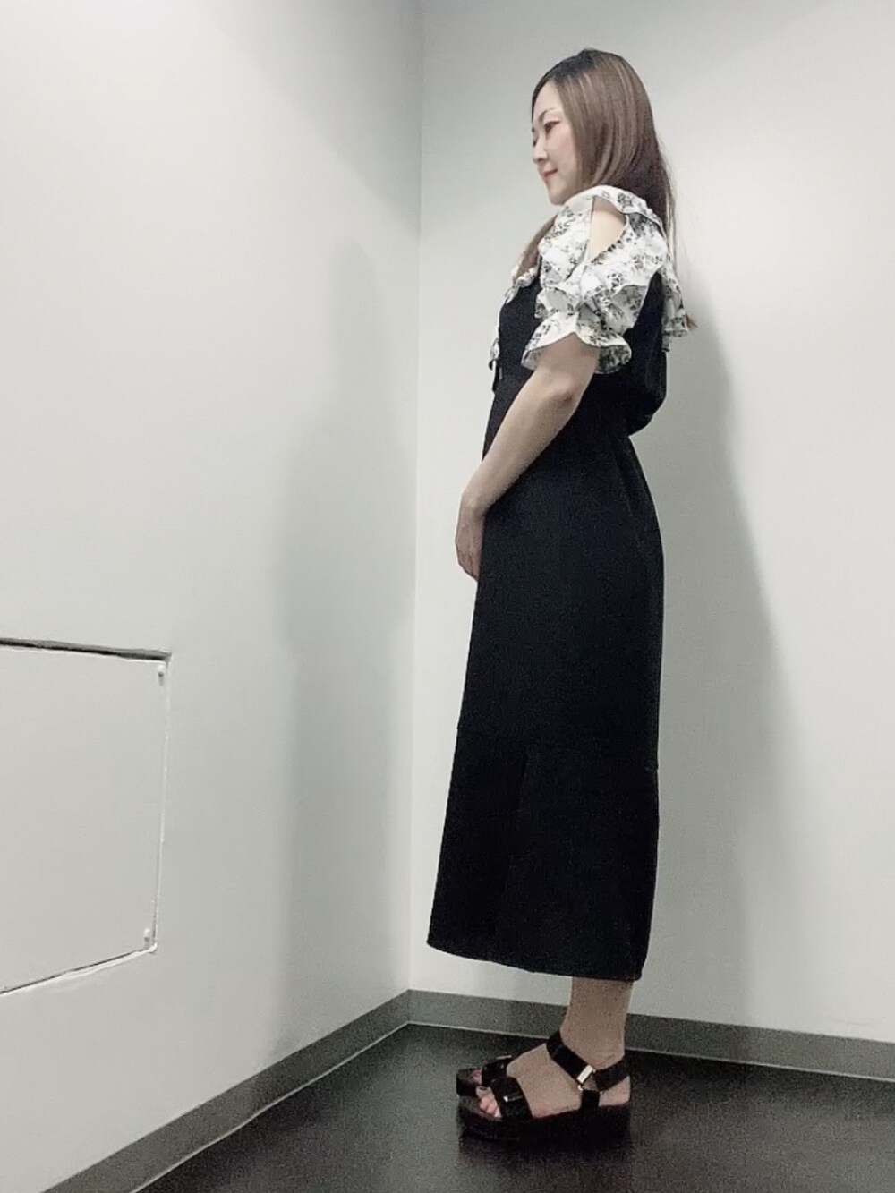 ブラック系のワンピース、ブラック系のサンダル、ゴールド系のピアス（両耳用）を着用したレディースの夏コーディネートの4枚目の写真