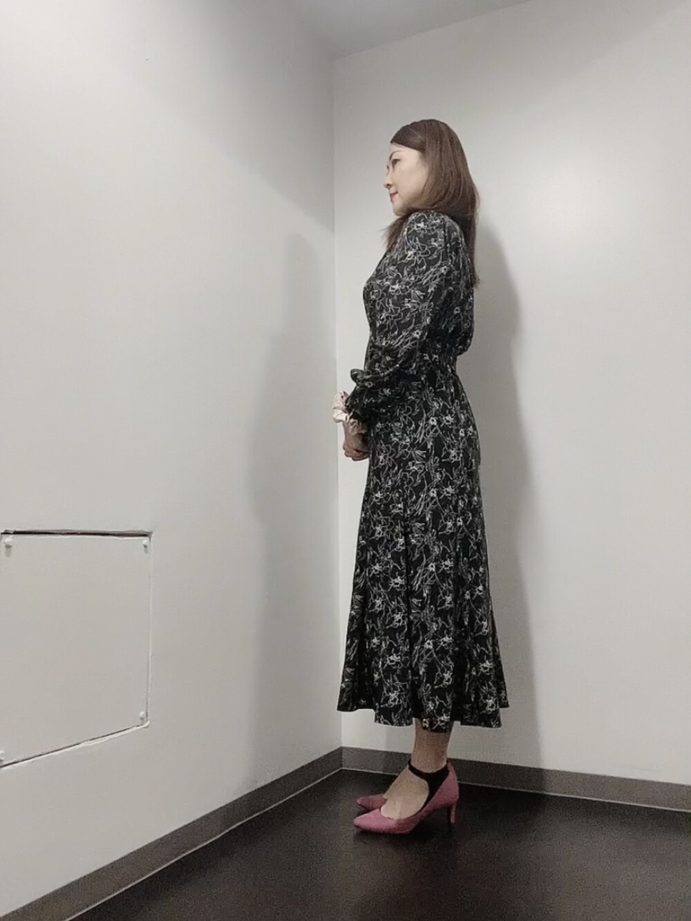 ブラック系のワンピース、ピンク系のパンプス、ホワイト系のピアス（両耳用）を着用したレディースの春コーディネートの4枚目の写真