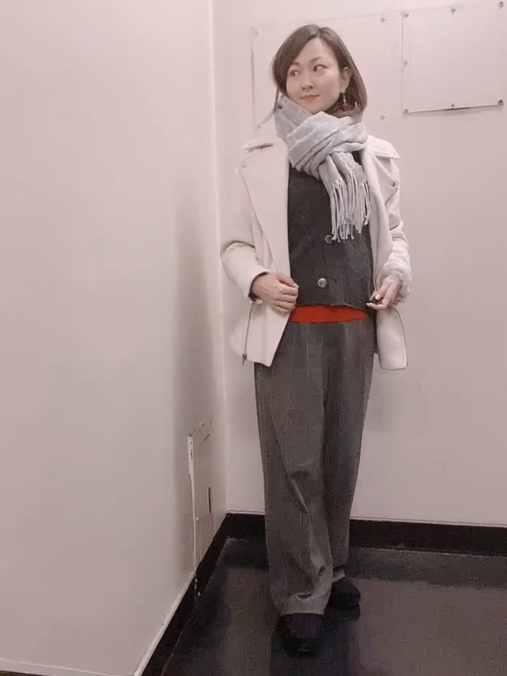 レッド系のニット/セーター、グレー系のスラックス、ブラック系のモカシン/デッキシューズを着用したレディースの冬コーディネートの2枚目の写真