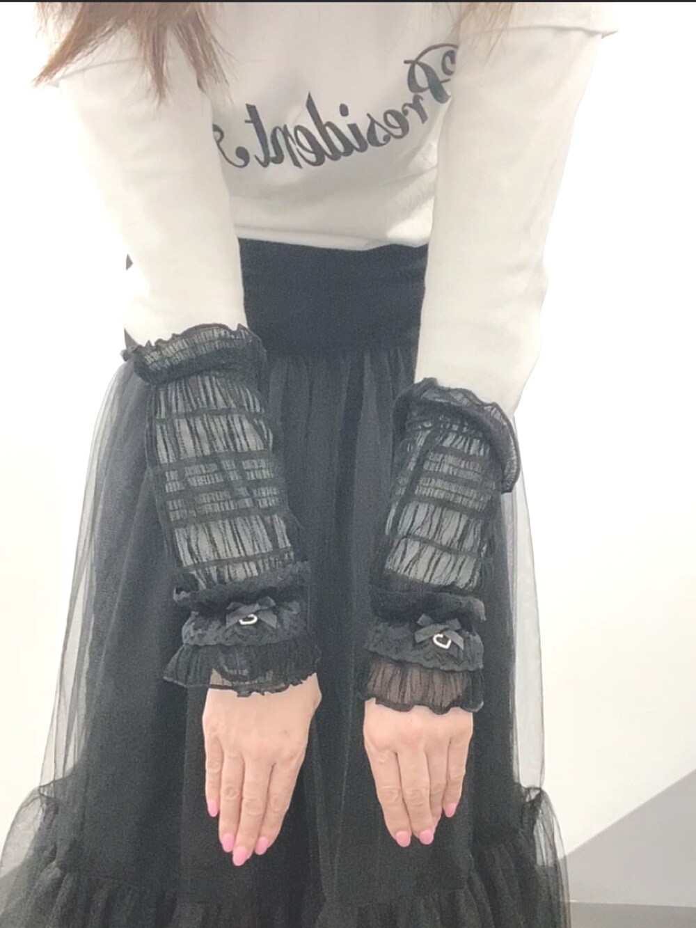 ホワイト系のTシャツ/カットソー、ブラック系のベスト、ブラック系のスカートを着用したレディースの春コーディネートの5枚目の写真