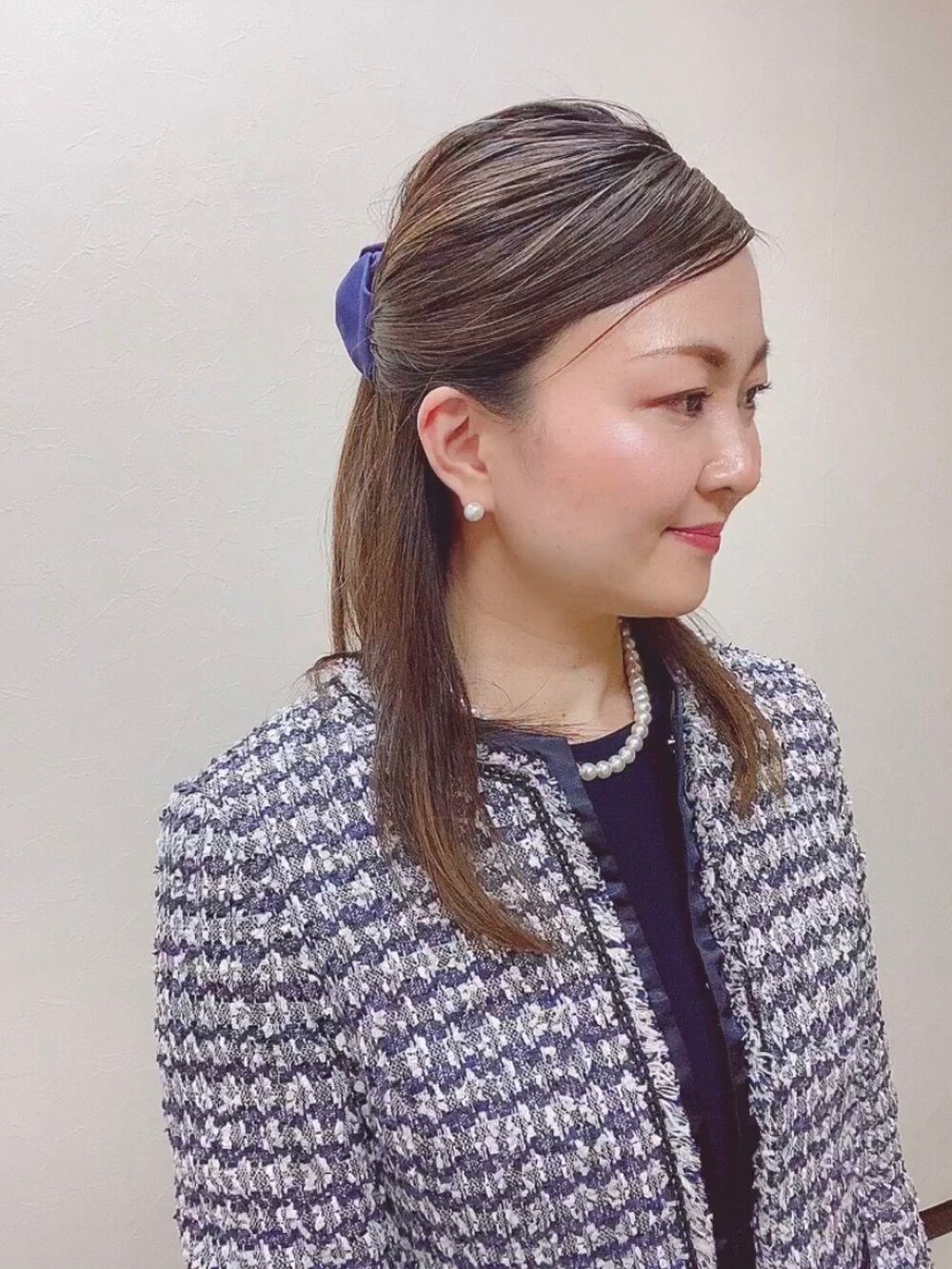 ブルー系のスーツセット、ブラック系のパンプス、ホワイト系のネックレスを着用したレディースの冬コーディネートの4枚目の写真
