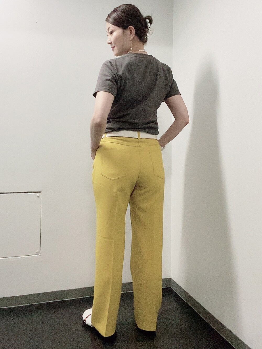 イエロー系のスラックス、ホワイト系のサンダル、グレー系のTシャツ/カットソーを着用したレディースの夏コーディネートの2枚目の写真