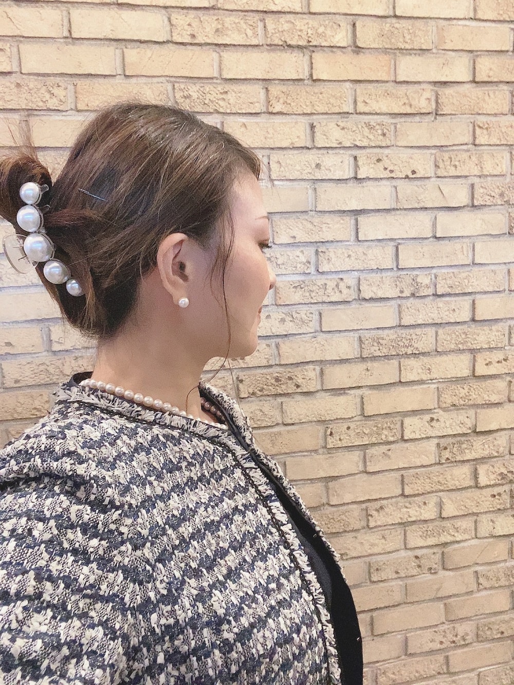 ブルー系のスーツセット、ブラック系のパンプス、ホワイト系のネックレスを着用したレディースの秋コーディネートの3枚目の写真