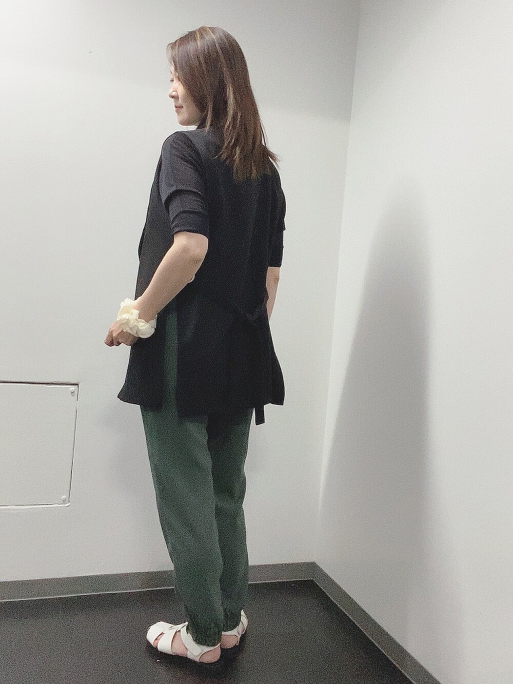 ブラック系のニット/セーター、グリーン系のその他パンツ、ホワイト系のサンダルを着用したレディースの夏コーディネートの2枚目の写真