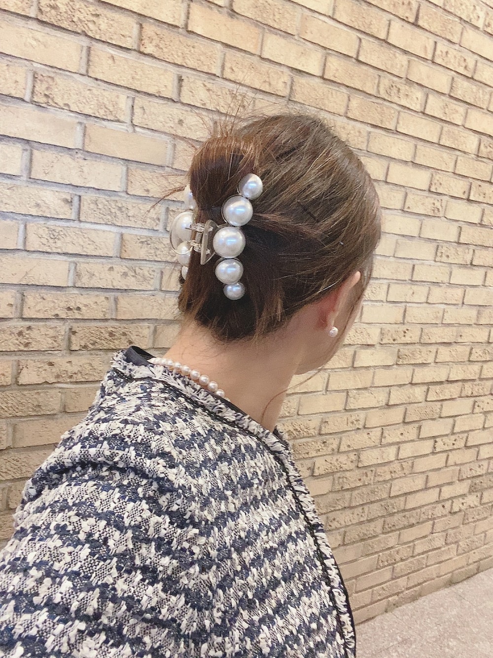 ブルー系のスーツセット、ブラック系のパンプス、ホワイト系のネックレスを着用したレディースの秋コーディネートの4枚目の写真