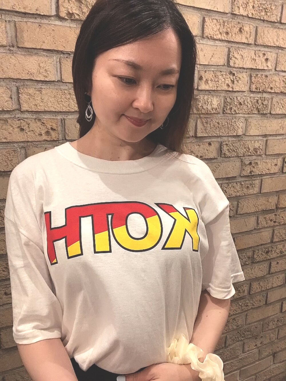 ホワイト系のTシャツ/カットソー、ブラック系のスカート、ブラック系のレインシューズを着用したレディースの夏コーディネートの5枚目の写真