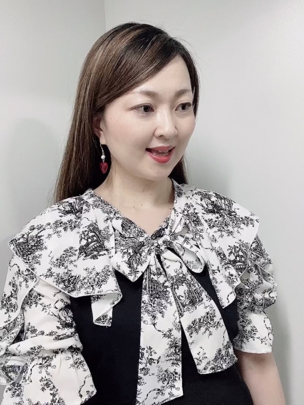 ブラック系のワンピース、ブラック系のサンダル、ゴールド系のピアス（両耳用）を着用したレディースの夏コーディネートの5枚目の写真